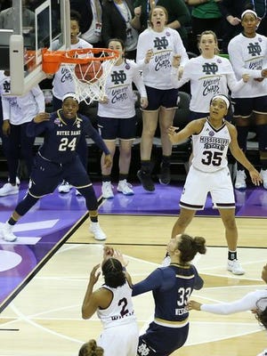Notre Dame's Arike Ogunbowale (24) hits the game-winner three-pointer as teammate Maureen Butler (third from right) watches from the bench.