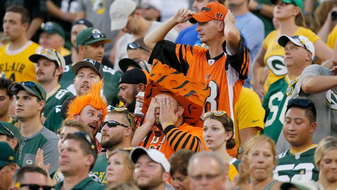 A pair of Bengals fans react as the Bengals fail to score on their possession in overtime of the NFL Week 3 game between the Green Bay Packers and the Cincinnati Bengals at Lambeau Field in Green Bay on Sunday, Sept. 24, 2017. The Bengals were dropped to 0-3 after a 27-24 overtime loss in Green Bay.