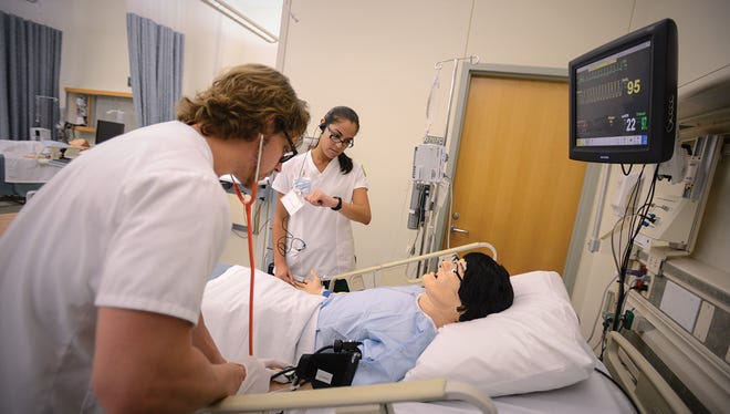 Pensacola State College nursing program students practice on a dummy.