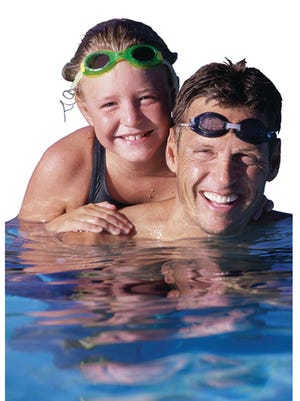 Portrait of a father and his daughter in a swimming pool