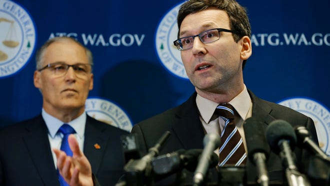 Washington Attorney General Bob Ferguson, right, talks to reporters as Gov. Jay Inslee, left, looks on, Monday, Jan. 30, 2017, in Seattle. Ferguson announced that he is suing President Donald Trump over an executive order that suspended immigration from seven countries with majority-Muslim populations and sparked nationwide protests.