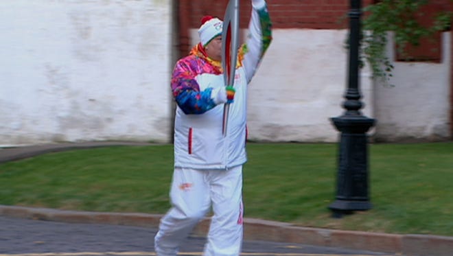 Torchbearer Savarsh Karapetyan indicates that his flame has blown out in Moscow on Sunday.