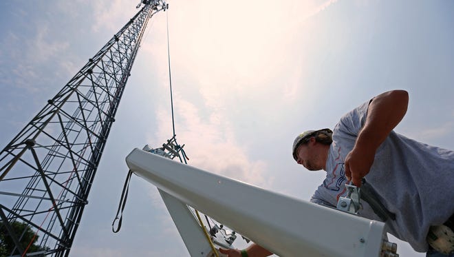 Ben Warner, of Lansing, Mich., loads and hoists updated antennas to the top of a Sprint cell tower on North Lynhurst Drive near Indianapolis Motor Speedway, Thursday, July 2, 2015, Indianapolis, Ind.
