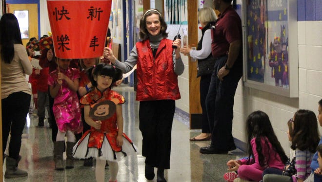 Kindergartner Katherine Zheng leads a parade through Mt. Horeb School hallways on Feb. 9 to celebrate the Chinese New Year. She is pictured with teacher Diane Harris. The celebration is one way the school district recognizes and teaches cultural diversity; in another way, a Chinese language program is taught to students in grades six to eight.