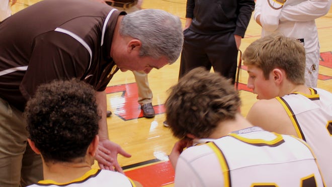 Kickapoo boys basketball coach Dick Rippee leans down to be heard over the stereo system at Ozark High School as he instructs starters, from left, Isaac Johnson, Jared Ridder and Travis Vokolek prior to a game against Barstow in the Scoreboard Guy Shootout.