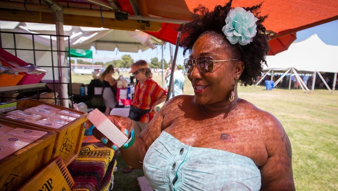 Lashanna Ansley, visiting from Albuquerque, examines a watermelon scented bar of soap at New Mexico Soap’s booth at the  the Red White & Brew Wine & Beer Festival on NMSU’s Intramural Fields, May 28, 2016.