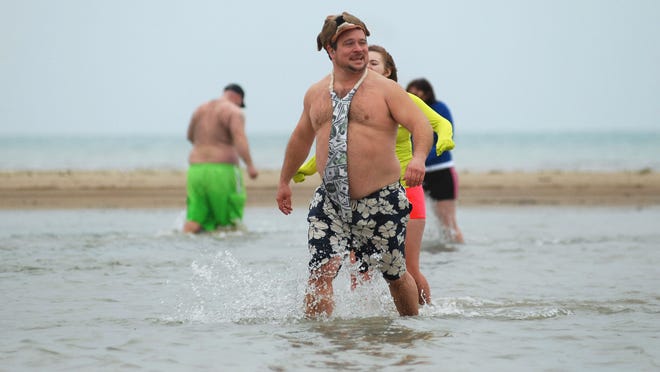 Sam Catanzaro, of Kimball Township, sports a large tie as he walks through the water during the 2012 Polar Bear Plunge.