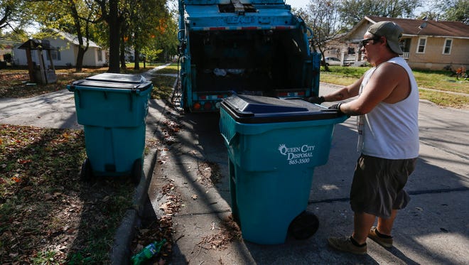 Thomas Nault, of Queen City Disposal, picks up trash on Prospect Avenue on Wednesday, November 2, 2016.