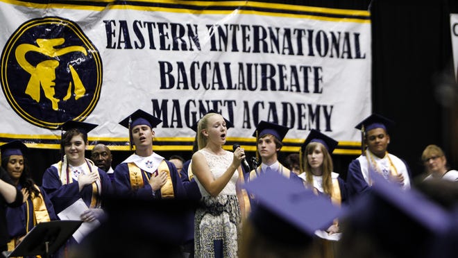 
Eastern High School student Roberta Glennon-Rule, flanked by the school’s 2014 Valedictorians, sings The National Anthem at Lansing Eastern's 86
th
 annual commencement May 31. Eastern could face a state takeover next fall, and the district is implementing new programs aimed at narrowing the gap between high- and low-achieving students and boosting test scores overall. Photo May 30, 2014 by MATTHEW DAE SMITH | for the Lansing State Journal]



