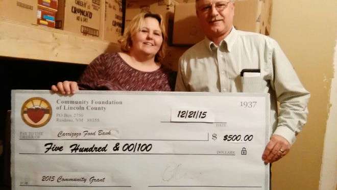 John Hemphill, representing the Community Foundation of Lincoln County, presents a check to Barbara Bradley Buttram of the Carrizozo Food Bank.