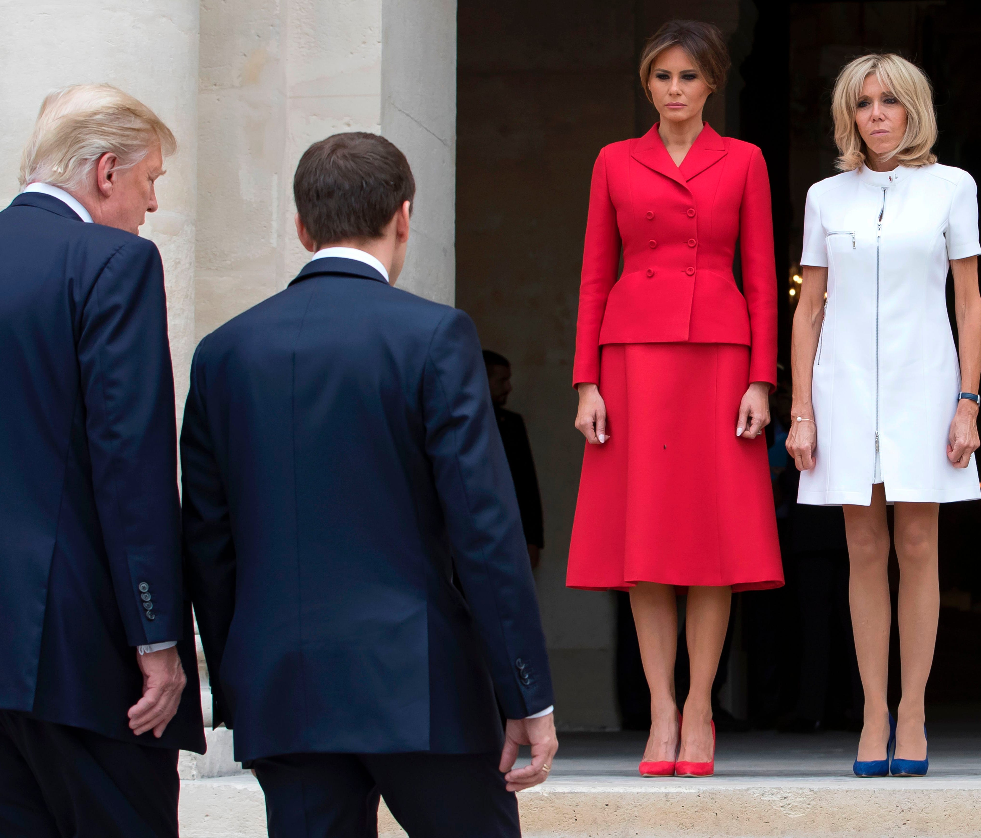 President Donald Trump, left, and French President Emmanuel Macron, right, walk toward first ladies Melania Trump and Brigitte Macron, as they arrive at the Army Museum during a welcome ceremony at Les Invalides in Paris, on July 13, 2017, as part of