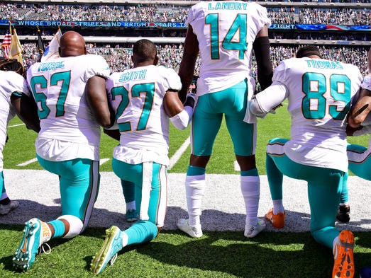 Dolphins players kneel with Jarvis Landry during the