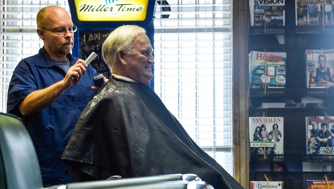 Chris Owens, the owner and the barber at, The Corner Barber Shop, gives loyal customer Jerry Hall a trim on Thursday morning. The welcoming interior of the shop keeps customers coming back for their haircuts.