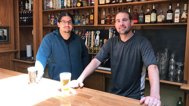Tyler Martell, left, and Jon Wells, right, stand behind the bar of Spartan Brewpub, which will open at 3056 Okemos Road later this month. Wells is the general manager and Martell is the head brewer.