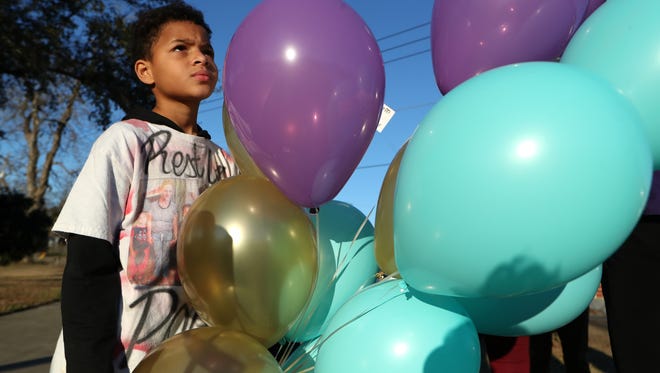 Devin, 11, prepares to release balloons with his family at Carter-Howell-Strong Park Friday as a tribute for his mom, Tiffany Nance, who was killed one year ago. Attached to the balloons was a note Devin wrote that read: “I miss you and I love you mom.”