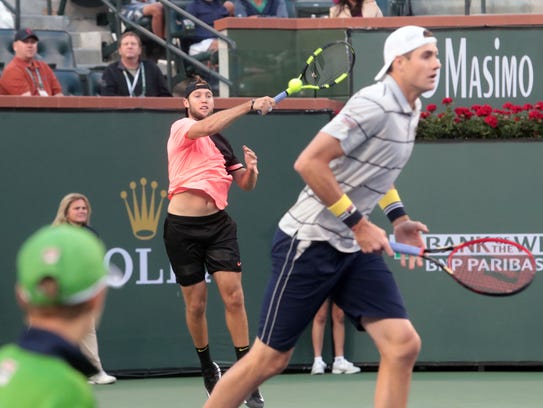 Jack Sock, left, and John Isner return the ball during