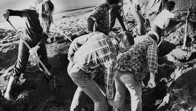 In this Feb. 13, 1980, file photo, FBI agents scour the sand of a beach of the Columbia River, searching for additional money or clues in 9-year-old D.B. Cooper skyjacking case in Vancouver, Wash.