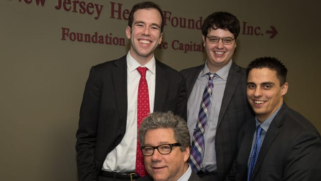 Three Rutgers graduates, from left to right, Nick Crider, Tom Villani, and Michael Johnson, have launched a biotech company called Visikol. They are pictured with James Simon, seated, a Rutgers professor who invented the company's technology with Villani. Johnson also is a graduate of Somerville High School.