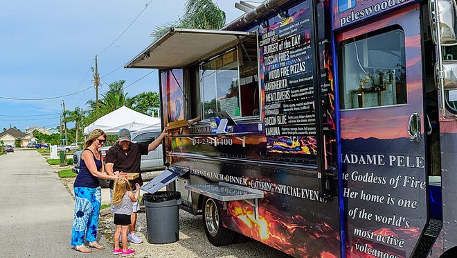 Jay and Michele Ruditis and their daughter Amelia Skye, 4, buy pizzas from Pele's Wood Fire food truck in St. Augustine in June 2021.