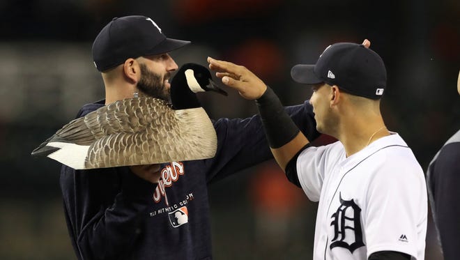 Tigers shortstop Jose Iglesias touches the team's Rally Goose mascot held by pitcher Mike Fiers after the Tigers' 5-2 win over the Twins on Wednesday, June 13, 2018, at Comerica Park.
