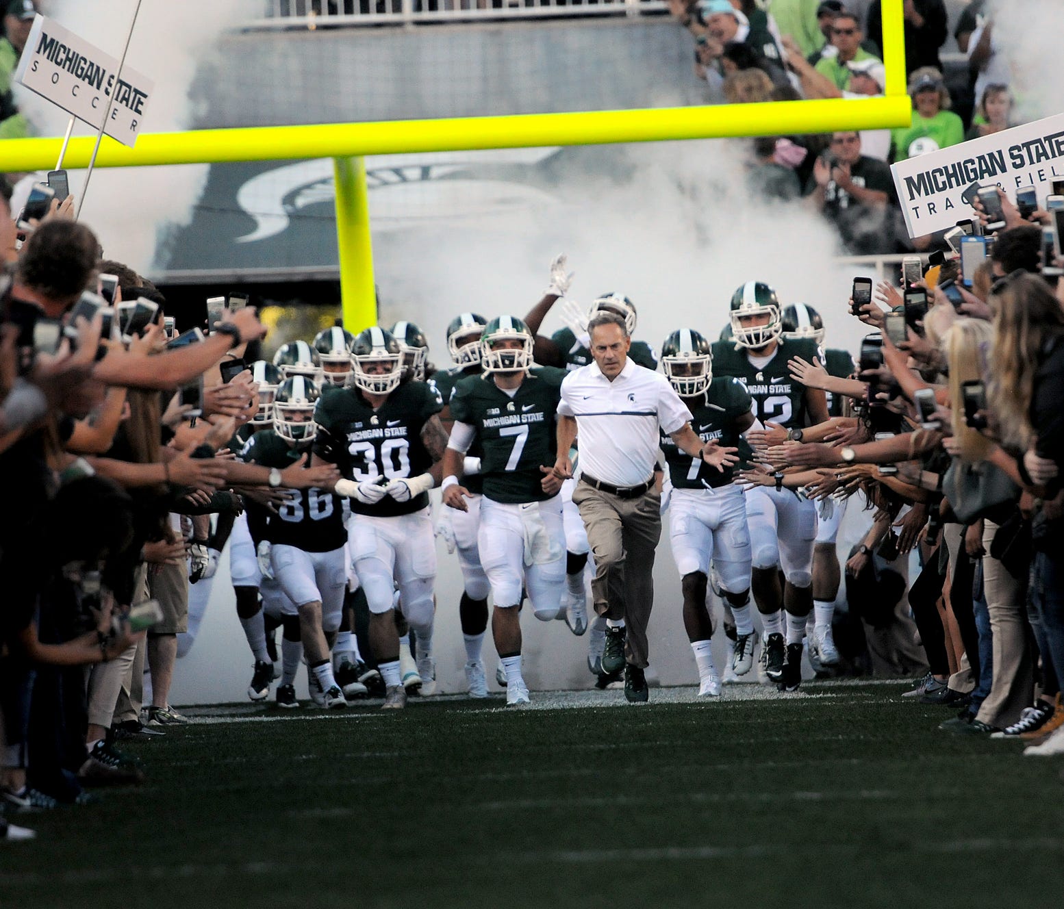 Head coach Mark Dantonio leads the Spartans onto the field before the first half of play against Furman in the Spartan's opening game of the 2016 season on Friday.