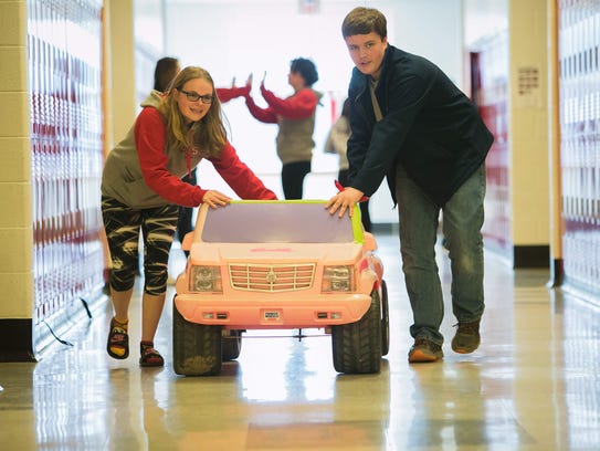 Eighth-graders Julia Kreck (left) and Nichlos Crawford at Smyrna Middle school roll a toy vehicle through the school hallway. The students are designing and modifying 6 and 12-volt battery-operated cars for children with disabilities.