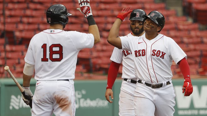 Boston Red Sox's Rafael Devers is congratulated by Mitch Moreland (18) after his two-run home run against the Philadelphia Phillies during the third inning of a baseball game Wednesday, Aug. 19, 2020, at Fenway Park in Boston.
