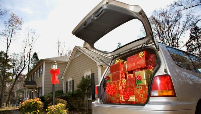 Car loaded with Christmas presents in driveway of home
