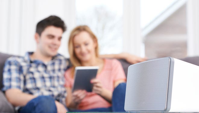 Couple Streaming Music From Digital Tablet To Wireless Speaker