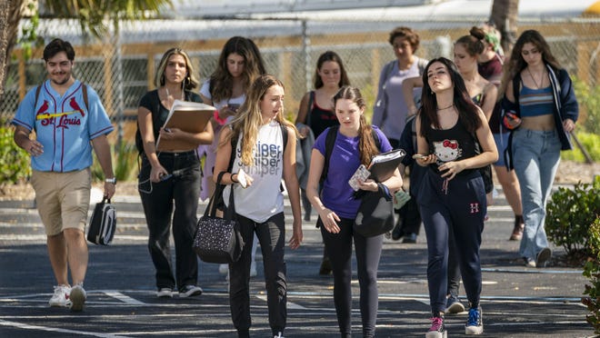 Dreyfoos School of the Arts students walk to the train station after school on Friday in West Palm Beach. The county closed classrooms to the school district's more than 190,000 students because of the coronavirus pandemic.