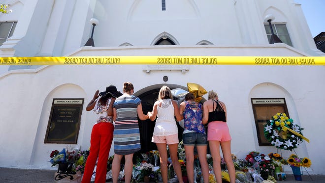 Women pray at a make-shift memorial in front of the Emanuel AME Church.