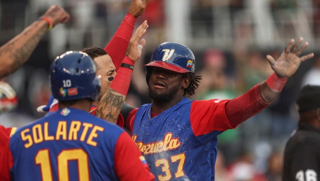 Venezuela's Odubel Herrera celebrates with teammates after scoring a run in a World Baseball Classic game against Italy.