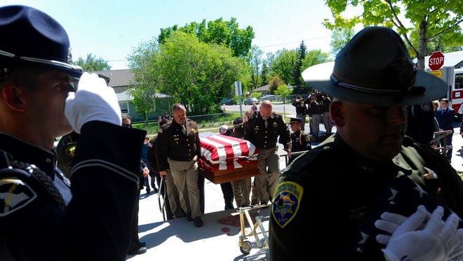 The casket carrying slain Broadwater County Deputy Mason Moore is carried into Three Forks High School, in Three Forks, Mont., Tuesday, May 23, 2017. Moore was shot and killed in the line of duty early on May 16, near Three Forks. (Thom Bridge/Independent Record via AP)