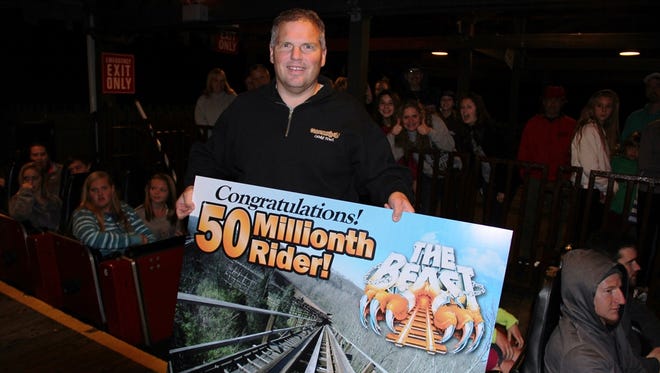 Mark Specht displays the winning sign he received on Friday night. Park officials announced that Specht was the 50 millionth rider of The Beast.