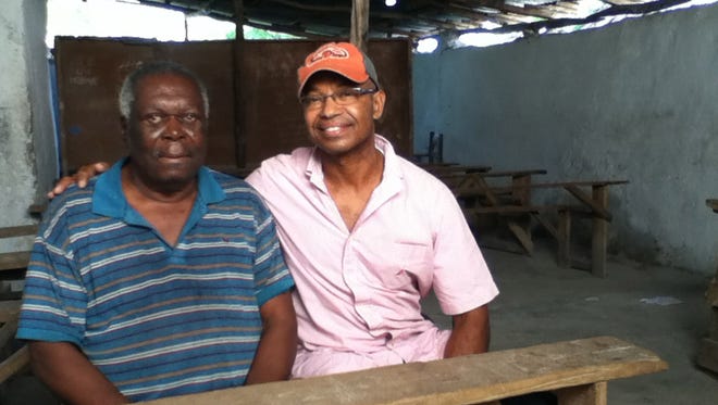 Jean-Robert Cadet of Madeira, Ohio, visits his first teacher, Jean Charles, 87, in his hometown of Petite Riviere, Haiti in July 2013. Though poor and enslaved as a domestic slave as a child and unable to pay, Charles let Cadet attend school for one year in this room in exchange to sweeping the yard. Cadet is trying to change his Haitian homeland's attitude toward children, all the while rescuing enslaved children one at a time.