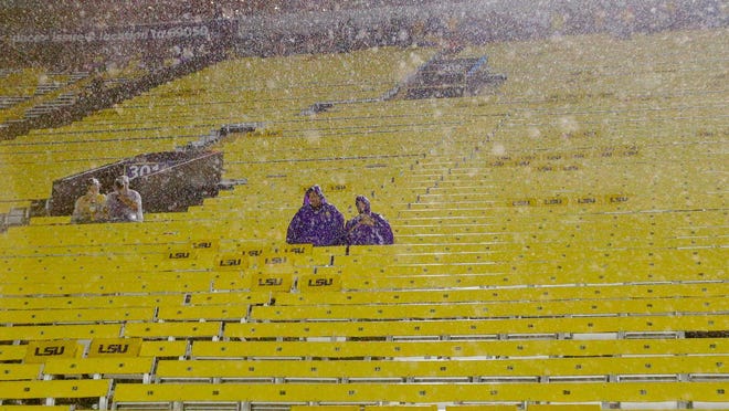 LSU Tigers fans sit in the stands during a weather delay where play was stopped during the first quarter of a game against the McNeese State Cowboys at Tiger Stadium.