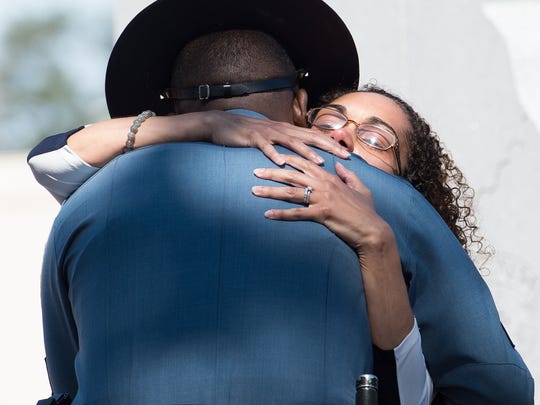 Louise Ballard, the wife of Delaware State Police Cpl. Stephen J. Ballard, hugs a Delaware State Police Trooper after placing a rose on the Delaware State Police Memorial during the Delaware State Police annual wreath-laying memorial ceremony at the Trooper’s Memorial in Dover.