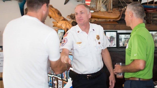 St. Lucie County Fire Chief Buddy Emerson (center) and St. Lucie County Tax Collector Chris Craft (right) greet guests at the local celebrity lunch.
