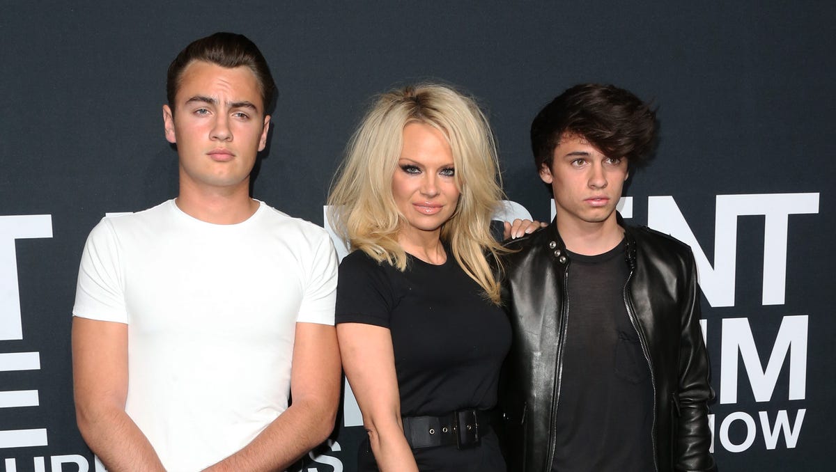 Pamela Anderson (center) and her sons Brandon Lee (L) and Dylan Lee at the Saint Laurent show in 2016.