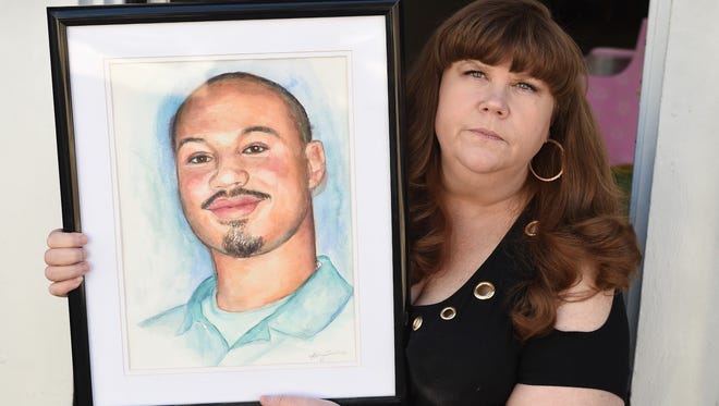 Deana Connelly holds a portrait of her son Ryan Connelly, 17, who was shot and killed on July 7th, 2012 while walking home from the store. 
