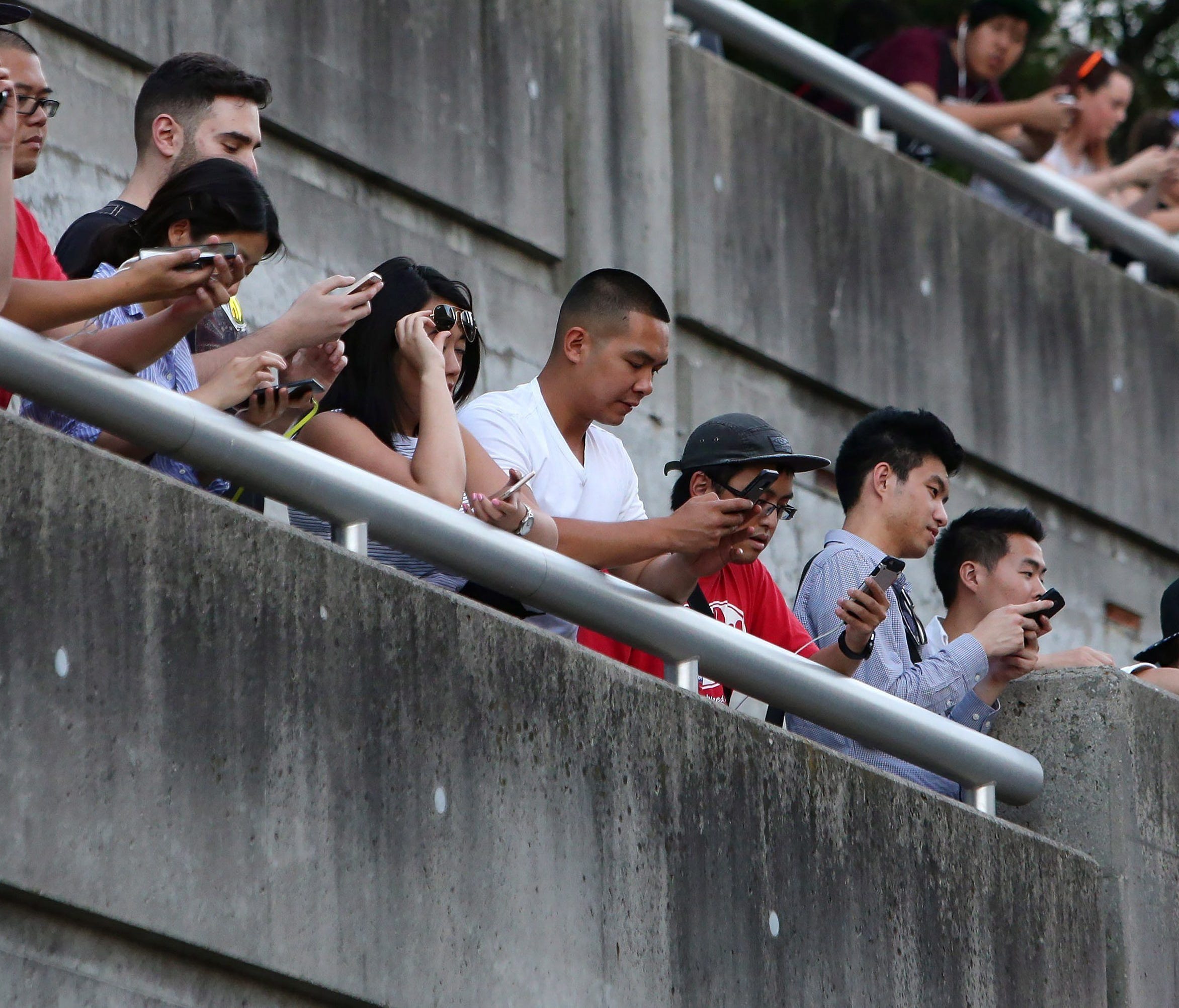 People use their phones in Toronto, Monday, July 18, 2016.