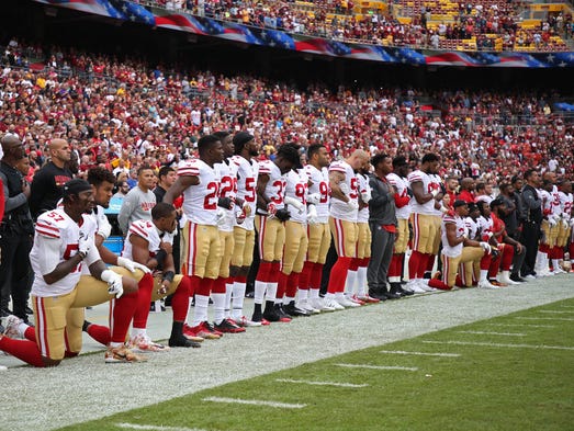 Multiple San Francisco 49ers players take a knee during
