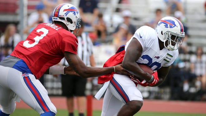 Karlos Williams takes a handoff from quarterback EJ Manuel during his first training camp practice.