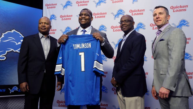 Detroit Lions first round draft pick guard Laken Tomlinson poses with a football jersey as he stands next to head coach Jim Caldwell, left, General Manager Martin Mayhew, second from right, and team president Tom Lewand on Friday, May 1, 2015 in Allen Park.