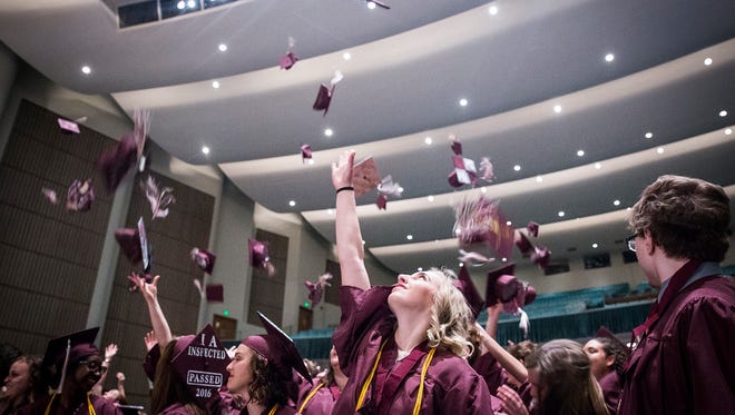 Graduating seniors toss their caps at the end of Indiana Academy's commencement ceremony at Emens Auditorium Saturday. 