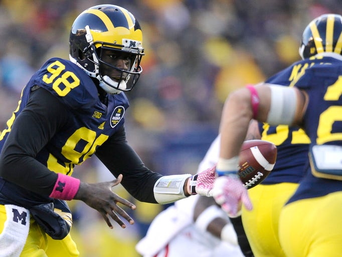Michigan quarterback Devin Gardner, left, dishes the