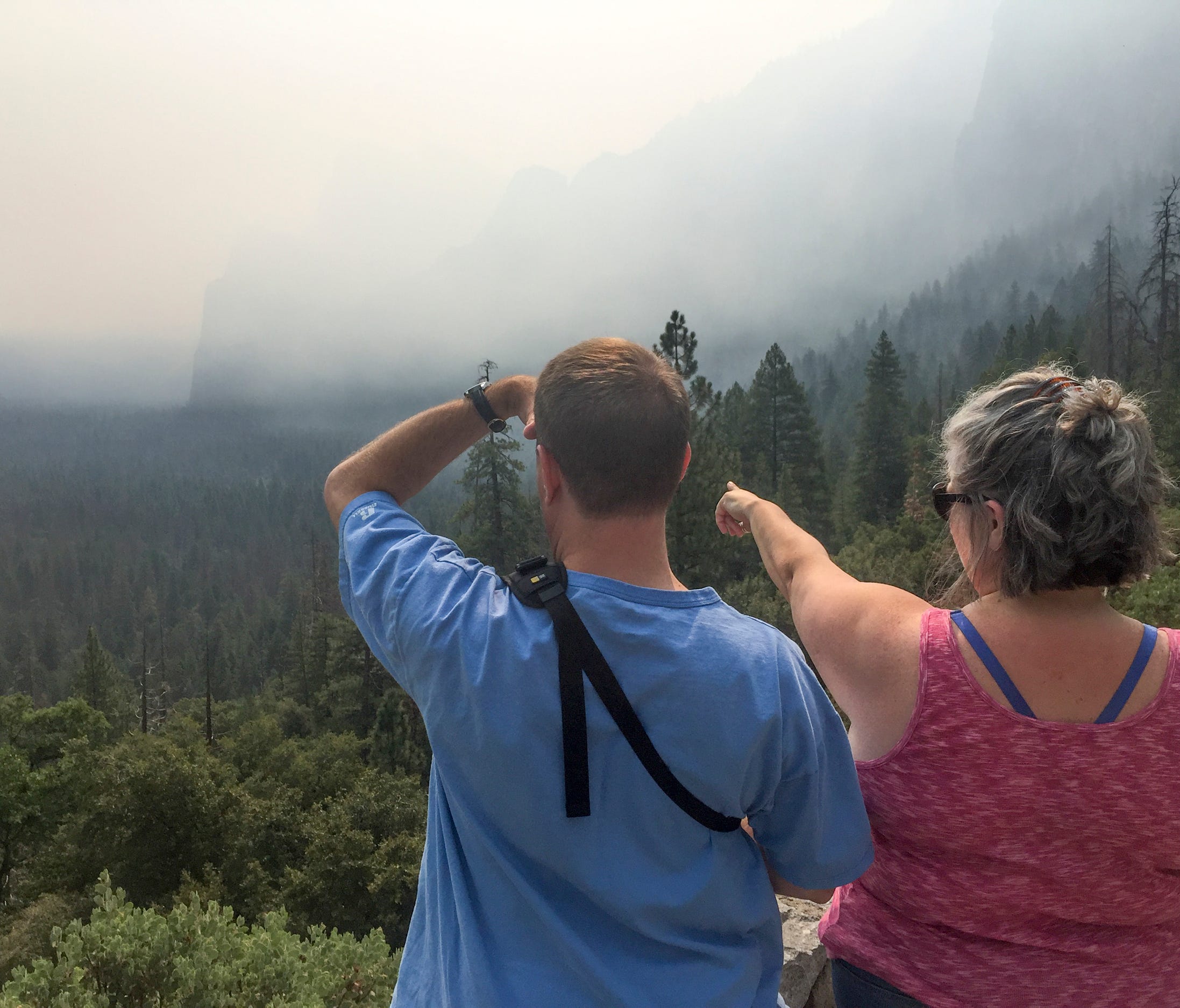 Smoke from the Ferguson Fire blocks some landmarks from the view of visitors Brad Lyons, left, and Courtney Richard at Tunnel View in Yosemite National Park on Tuesday, July 24, 2018.