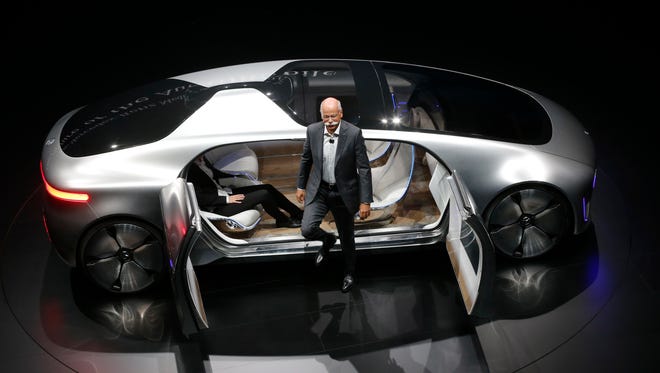 Daimler CEO Dieter Zetsche leaves an autonomous driving vehicle during an event of the Daimler group on the eve of the Frankfurt Auto Show in Frankfurt, Germany, Sept. 14, 2015. (AP Photo/Michael Probst)