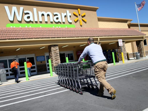 Walmart employee Yurdin Velazquez pushes grocery carts