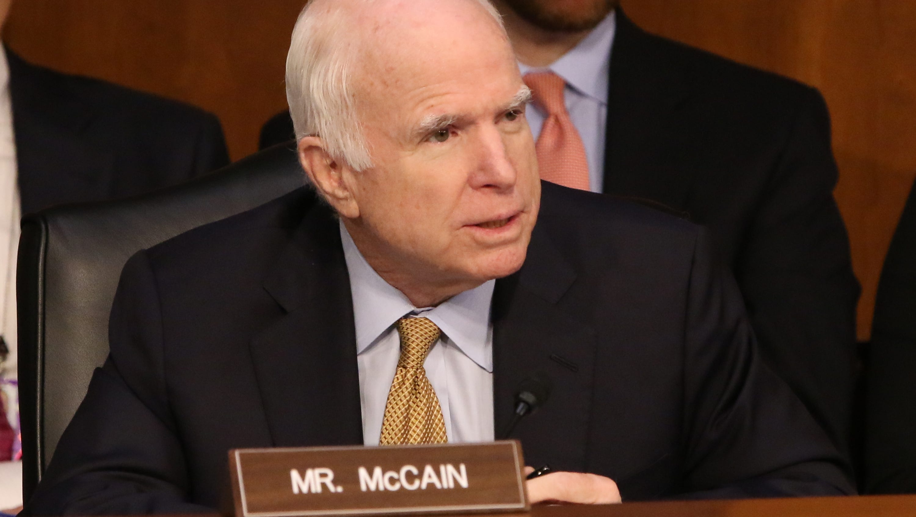 Sen. John McCain listens to former FBI director James